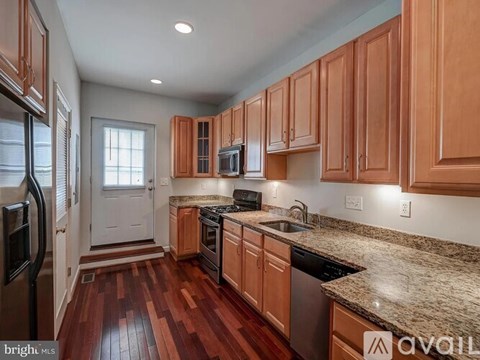 A kitchen with wooden cabinets and a granite countertop.