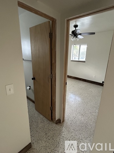 A room with a ceiling fan and a door.