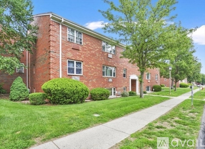 A brick building with a green lawn in front.