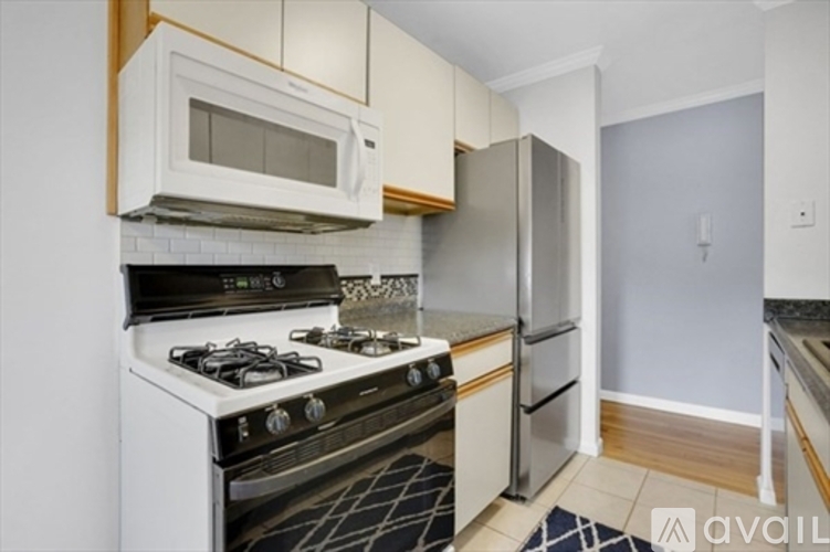 A kitchen with a stove, microwave, and refrigerator.