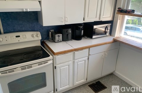 A kitchen with white cabinets and a blue backsplash.