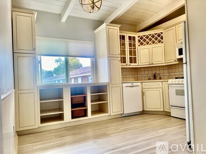 A kitchen with wooden floors and white appliances.