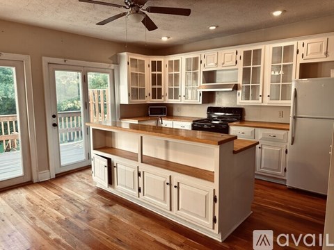 A kitchen with wooden floors and white cabinets.