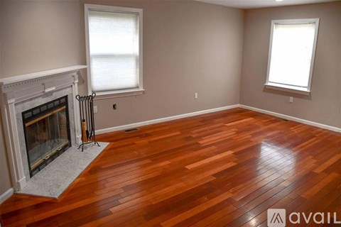 A room with a fireplace and wood flooring.