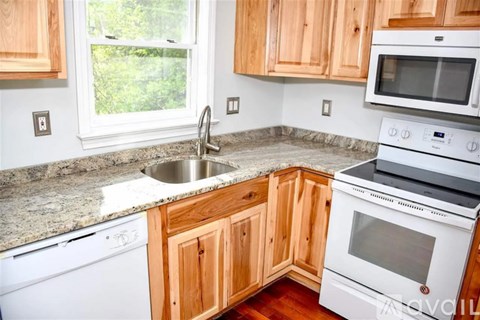 A kitchen with wooden cabinets and white appliances.