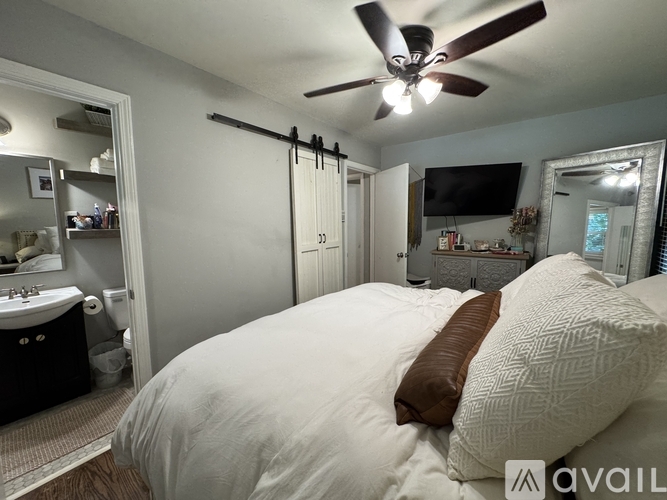 A bedroom with a large bed and a ceiling fan.