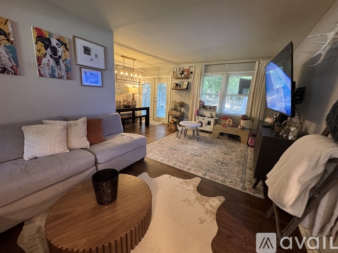 A living room with a grey couch, a coffee table, and a television.