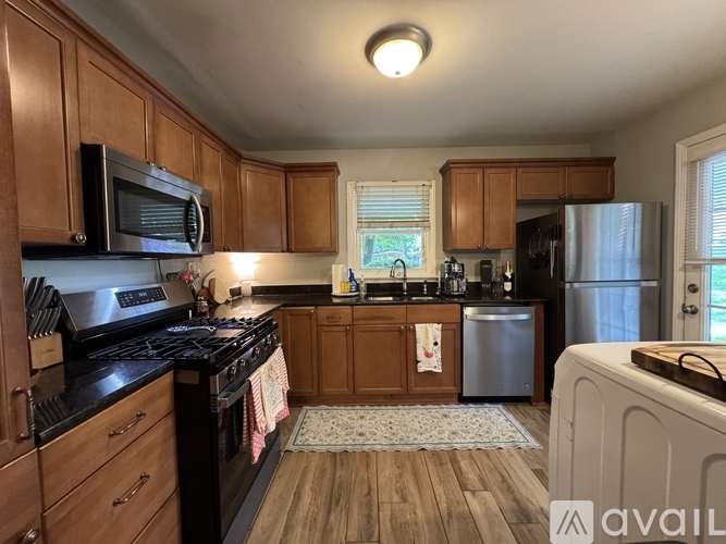 A kitchen with wooden cabinets and black appliances.