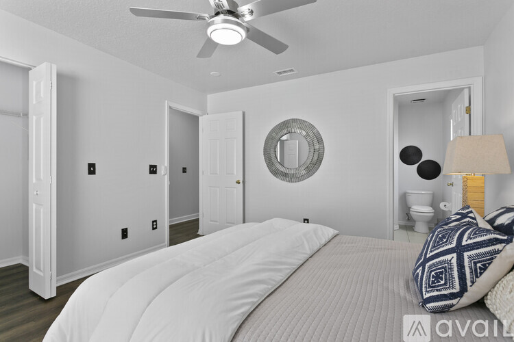 A bedroom with a large bed and a ceiling fan.