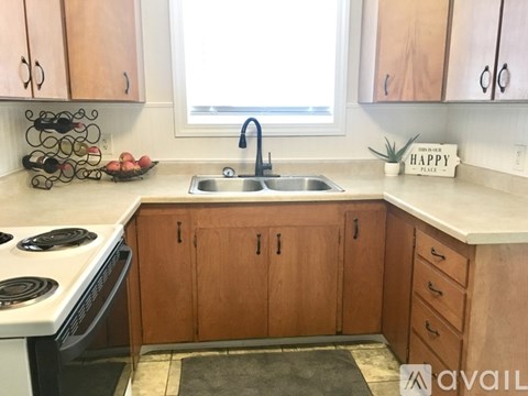 A kitchen with wooden cabinets and a white stove top.