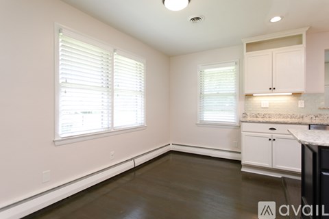 A kitchen with white cabinets and a marble countertop.