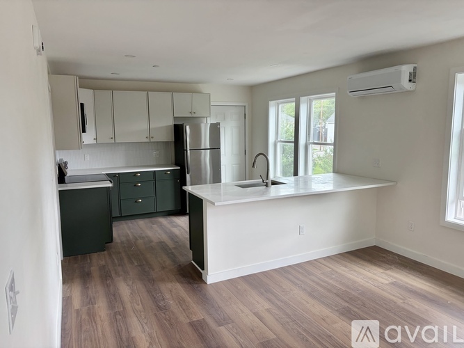 A kitchen with a white countertop and green cabinets.