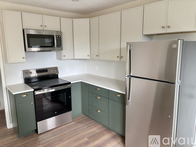A kitchen with a stainless steel refrigerator, oven, and microwave.
