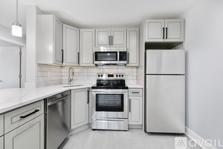 A kitchen with white cabinets and stainless steel appliances.
