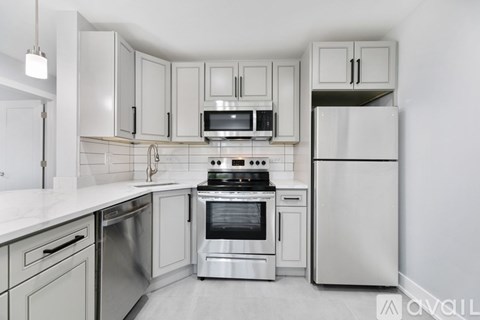 A kitchen with white cabinets and stainless steel appliances.