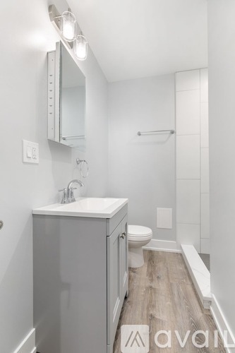 A bathroom with a white sink and toilet.