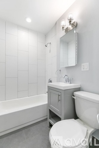 A white bathroom with a toilet, sink, and bathtub.