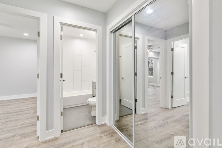 A bathroom with a toilet and a mirrored door.
