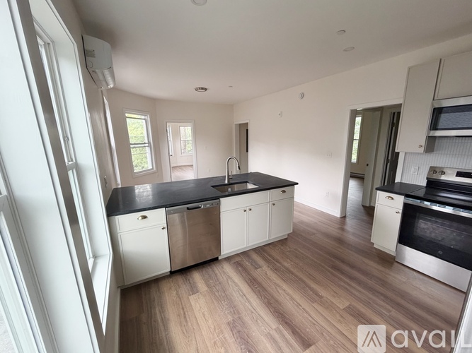 A kitchen with white cabinets and a black countertop.