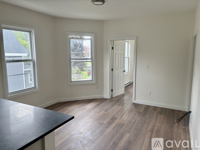 A room with a black countertop and wooden flooring is available for rent.