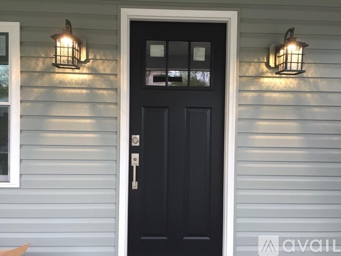 A black door with a silver handle and a glass window above it.