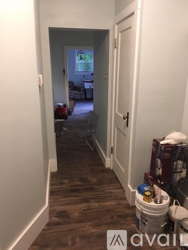 A hallway with a white door and a white wall.