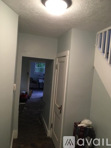 A hallway with a door on the right and a window in the distance.