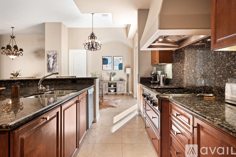A kitchen with dark wood cabinets and granite countertops.