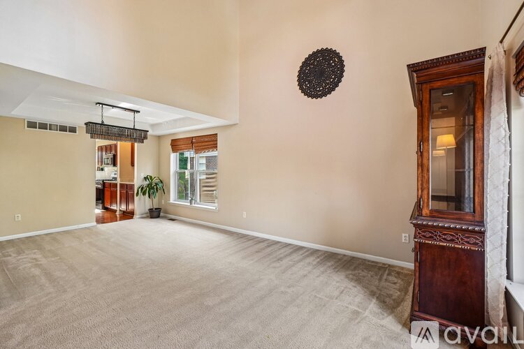 A spacious room with a carpeted floor and a wooden cabinet.