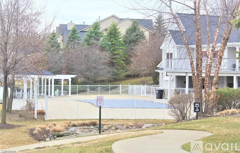 A white house with a pool in front of it.