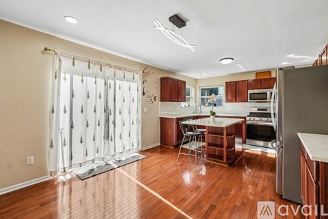 A kitchen with wooden floors and a dining table with chairs.