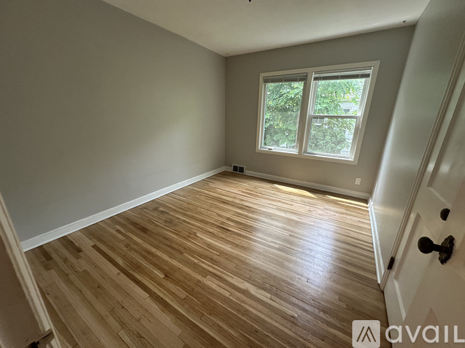 A room with wooden flooring and a window.