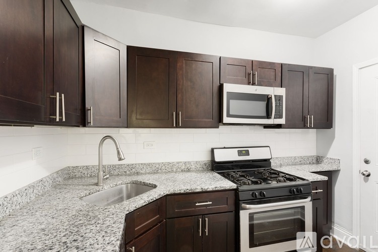 A kitchen with brown cabinets and a granite countertop.