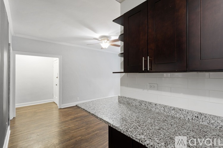 A kitchen with dark wood cabinets and a granite countertop.