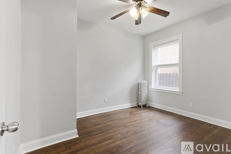 A room with a ceiling fan and a window with blinds.
