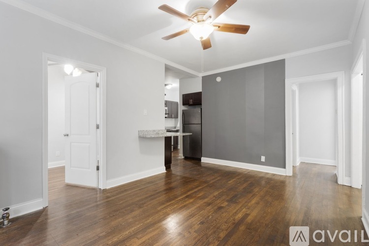 A spacious room with a ceiling fan and wooden flooring.