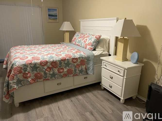 A bedroom with a bed, nightstand, and lamp.