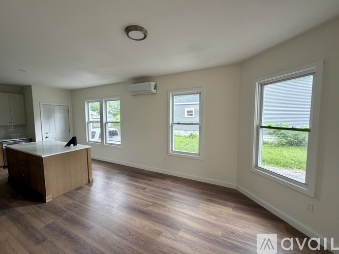 A room with a desk and a window overlooking a green area.