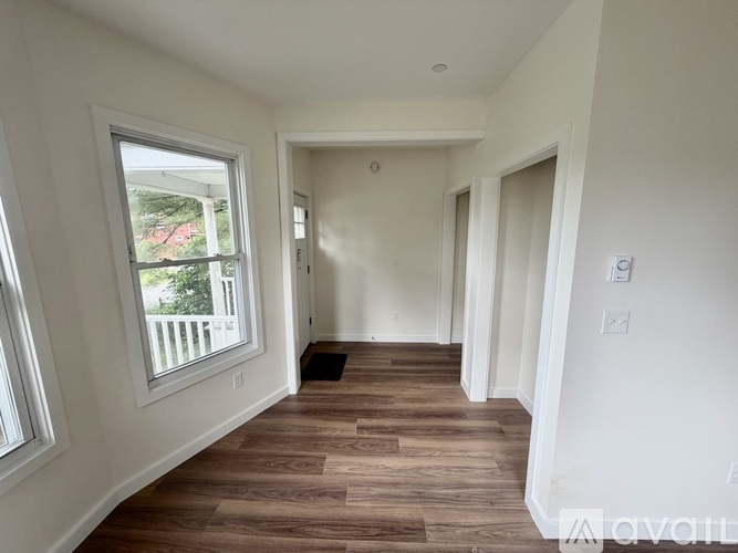 A long hallway with wood floors and white walls.