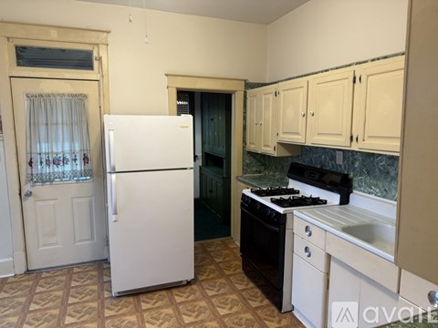 A kitchen with a white fridge and black stove.