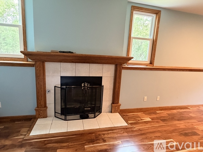 A living room with a fireplace and wood flooring.