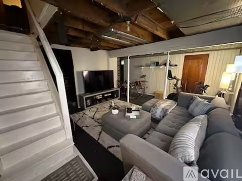 A living room with a grey couch and a television.