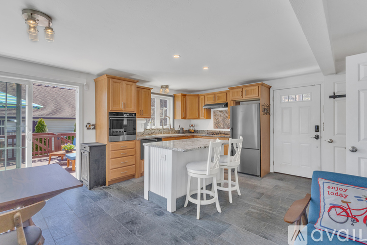 A kitchen with wooden cabinets and a white island.