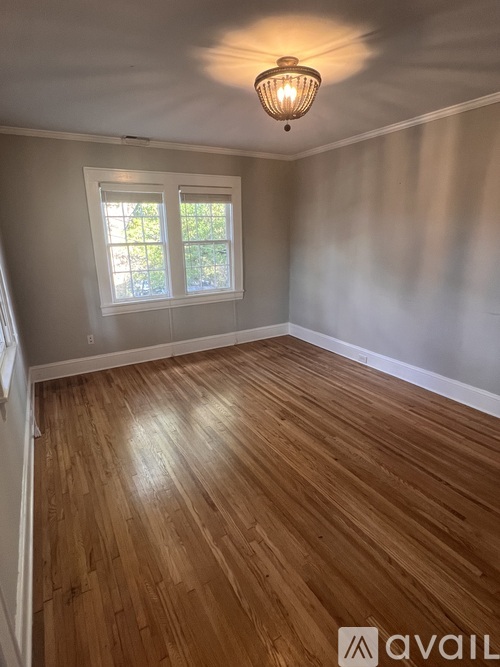 A room with wooden flooring and a window.