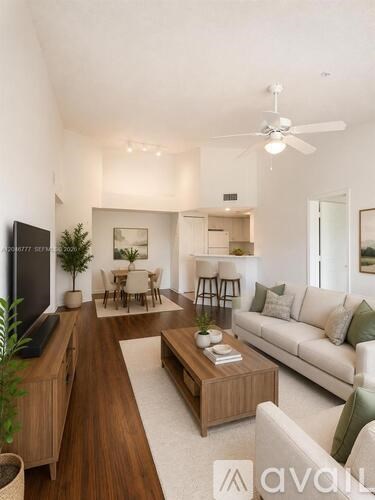 A modern living room with a white couch, wooden coffee table, and a flat-screen TV.