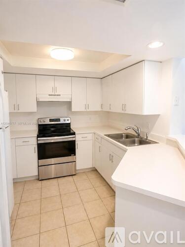 A kitchen with white cabinets and a stainless steel oven.