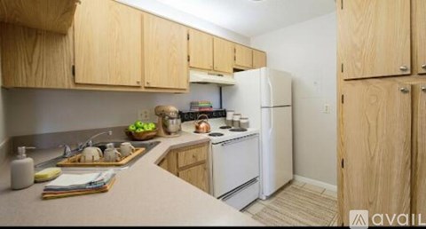 A kitchen with wooden cabinets and a white refrigerator.