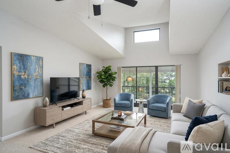 A living room with a television, two chairs, a sofa, and a coffee table.