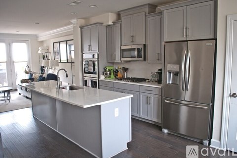 A modern kitchen with a large island and stainless steel appliances.