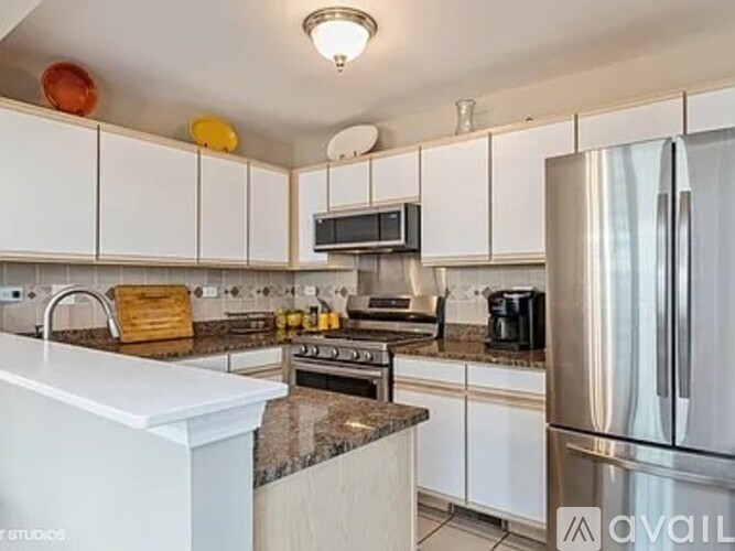 A kitchen with white cabinets and a granite countertop.